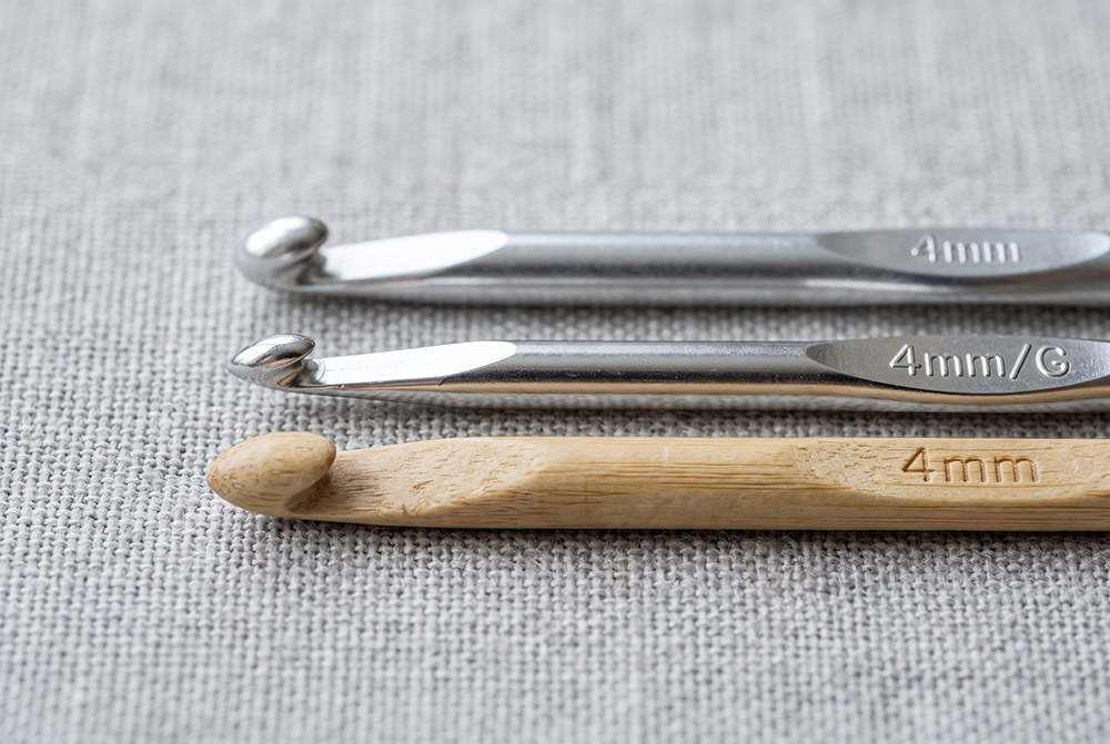 Gros plan sur les têtes de trois crochets 4 mm : tête arrondie, tête pointue à gorge profonde, tête en bambou